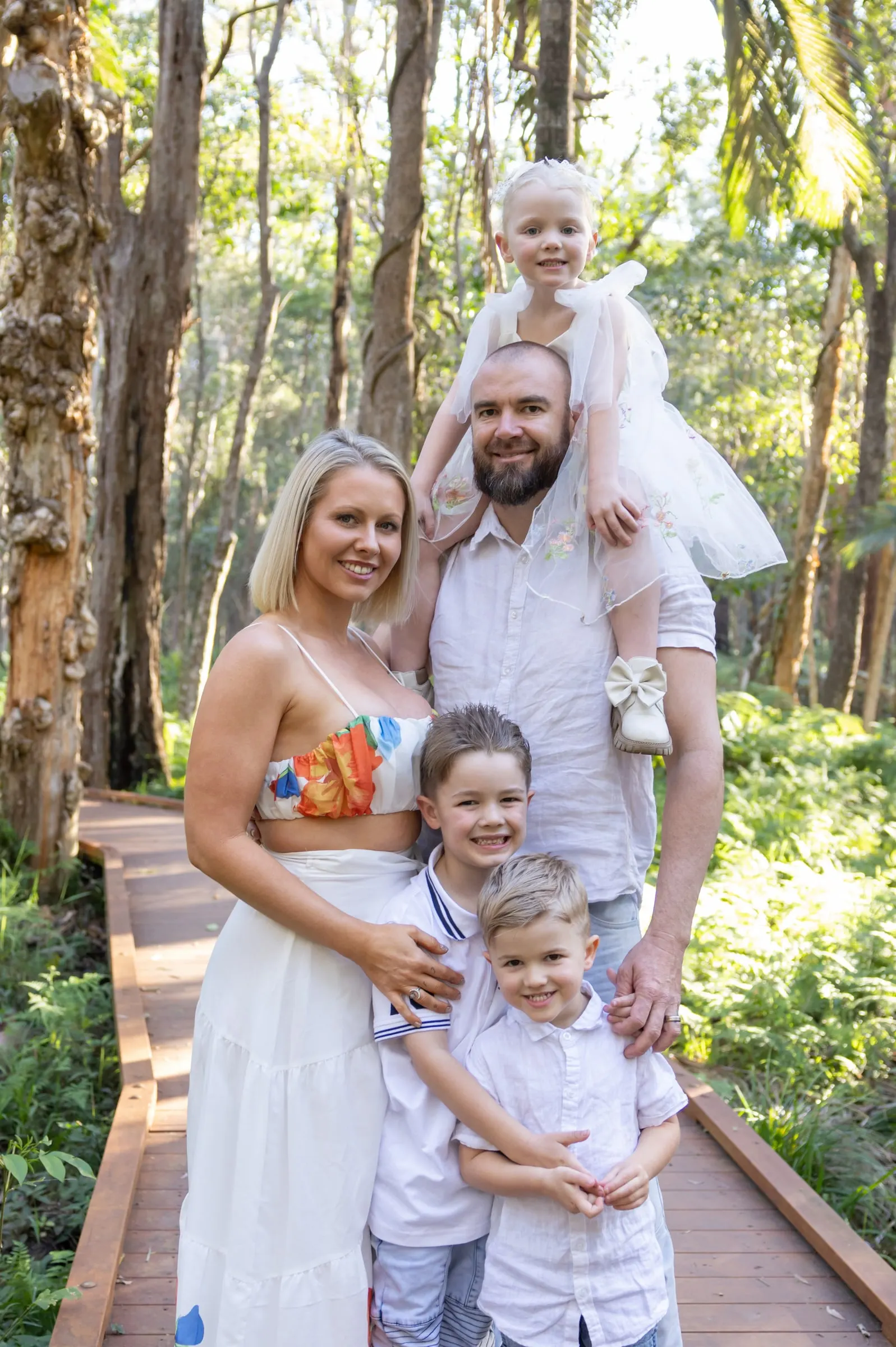 Family of five on a bush boardwalk, little one on dad's shoulders