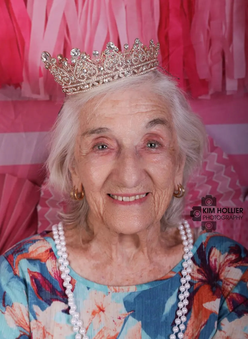 Birthday girl turning 92, in a tiara and pearls on pink
