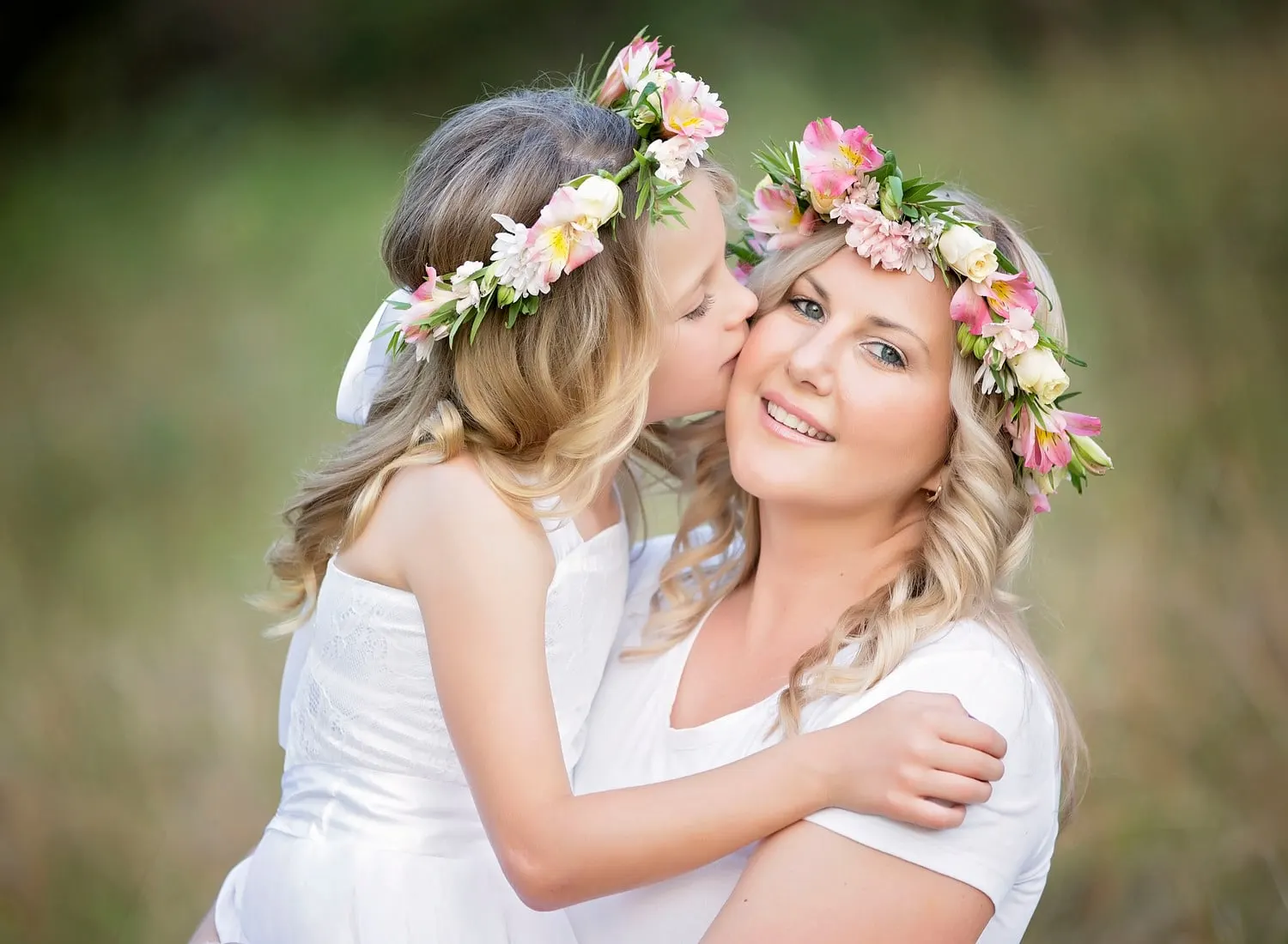 Daughter kissing her mum, both in flower crowns