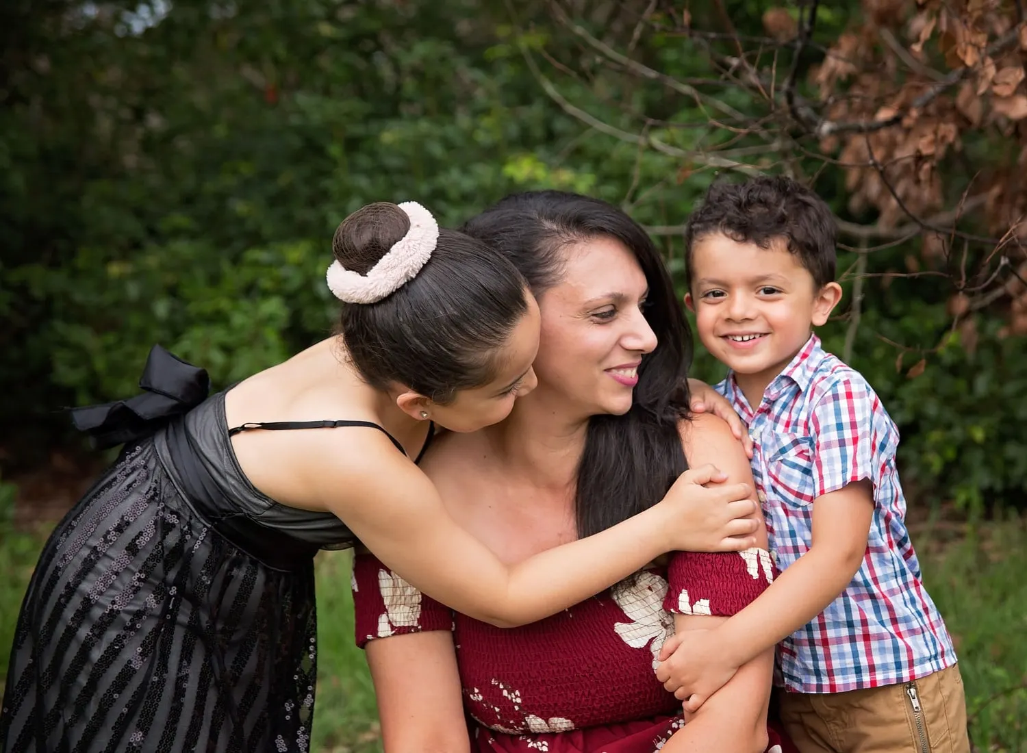 Mum hugged by her daughter and son in the garden