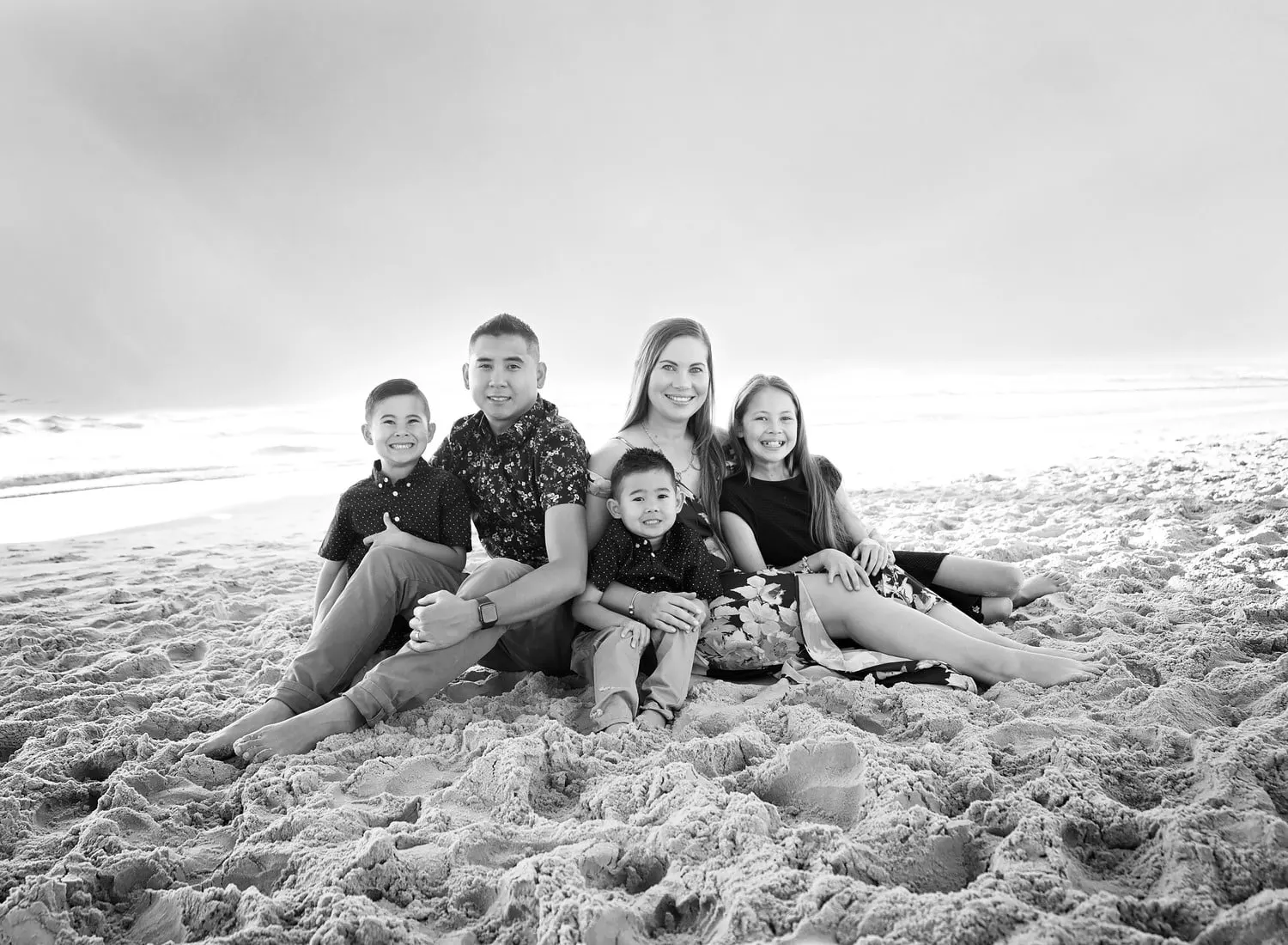 Black and white photo of a family of five on the beach