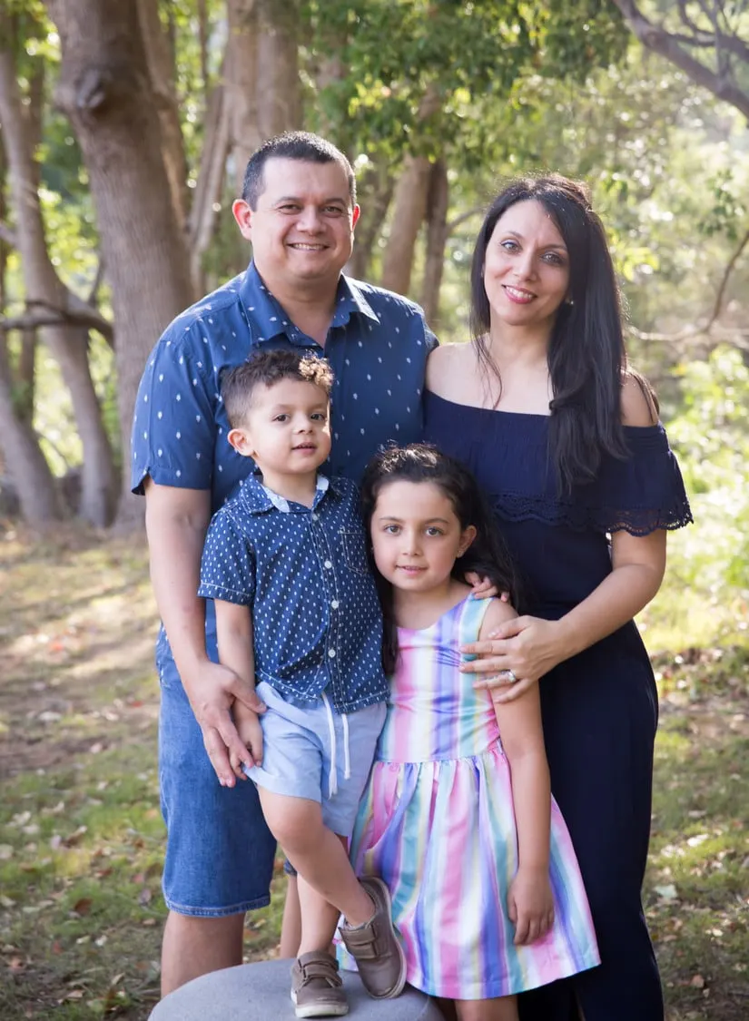 Family of four standing among trees