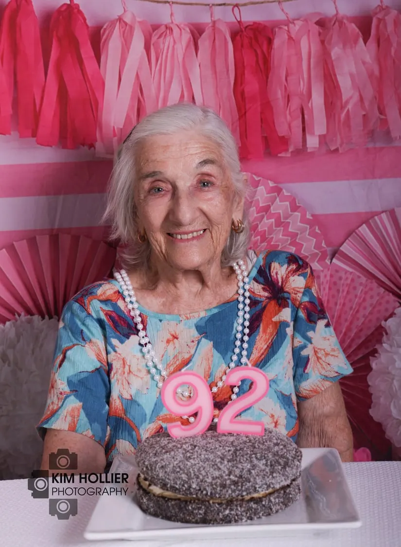 Birthday girl smiling with her 92nd birthday cake