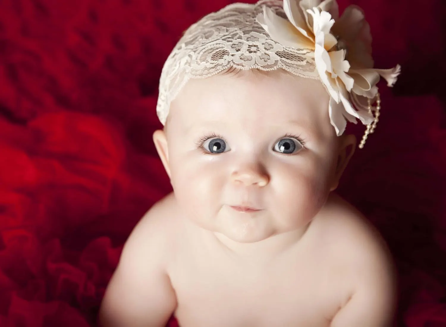 Baby in a lace headband on red