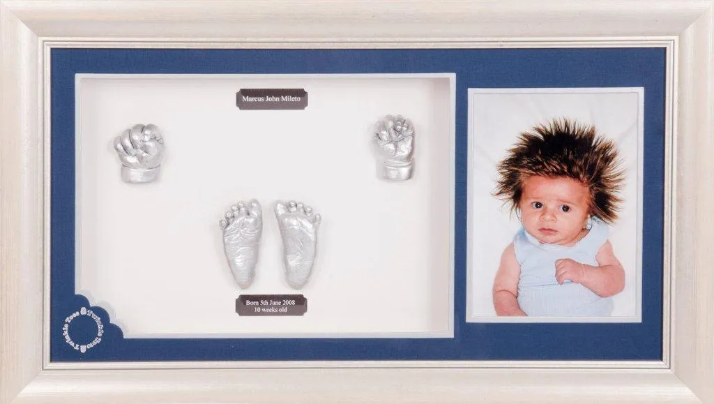 Silver baby hands and feet with a toddler photo, on a blue mat in a white frame
